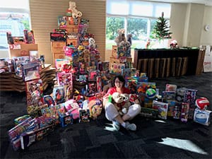 Woman sitting in front a large amount of presents