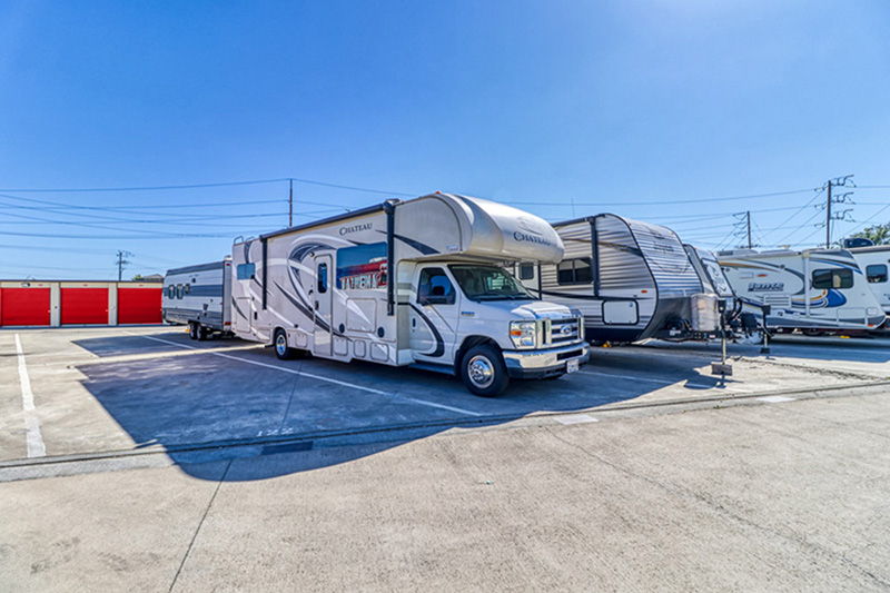 RVs are parked in a storage parking lot.